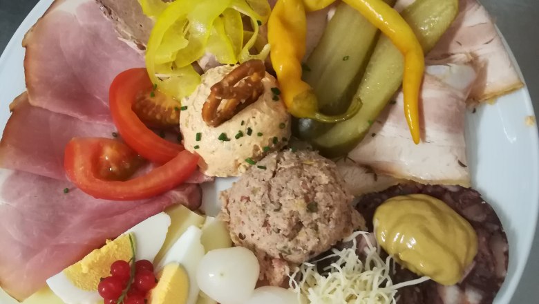 Ein Teller mit verschiedenen Wurst- und K&auml;sesorten, Eiern, Zwiebeln, Paprika und Aufstrichen.