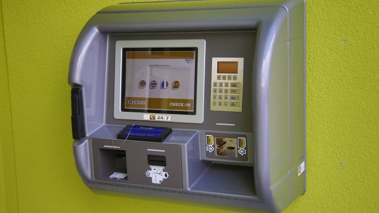 Ein Check-in-Automat an einer gr&uuml;nen Wand.