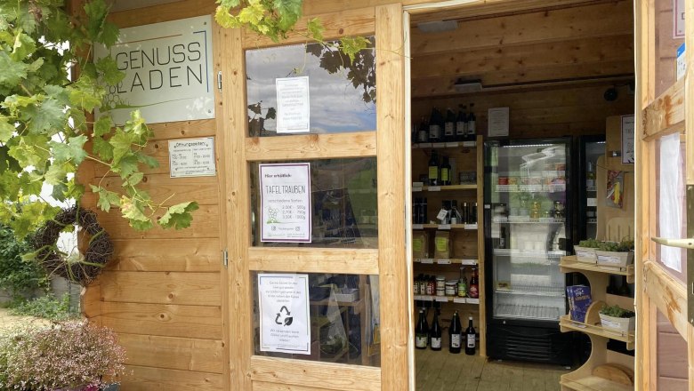 Ein kleiner Holzladen mit Weintrauben und Getr&auml;nken im Inneren.