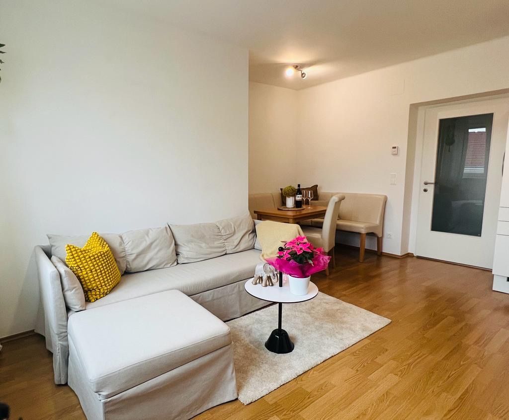 Moderner Wohn- und Essbereich mit Sofa, Tisch und Stühlen.