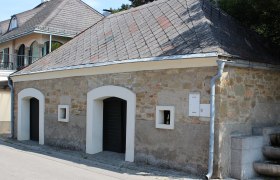 Ein traditionelles Geb&auml;ude mit Steinmauer und Schieferdach in Langenzersdorf.