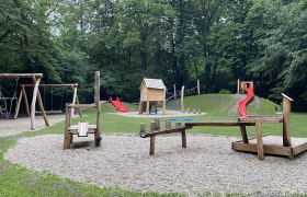 Spielplatz im Stadtpark mit Schaukeln, Rutsche und Kletterger&uuml;st.