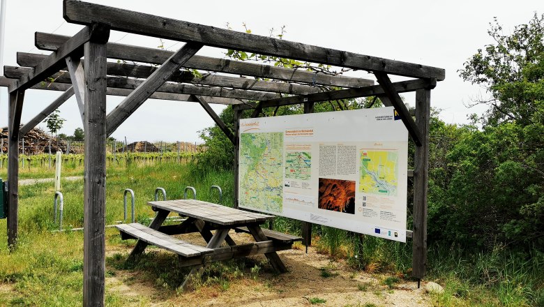 Radlerrastplatz mit Holztisch und Infotafel an der Weinstra&szlig;e im Weinviertel.
