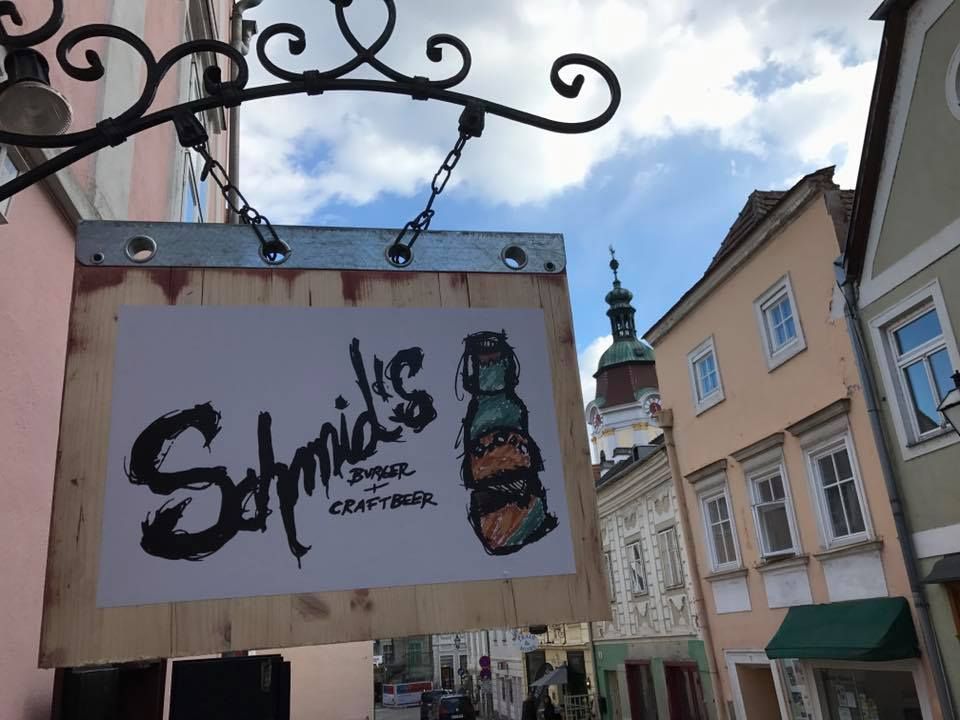 Schild von Schmid's Burger und Craftbeer an einer Hauswand in einer Altstadtstraße.