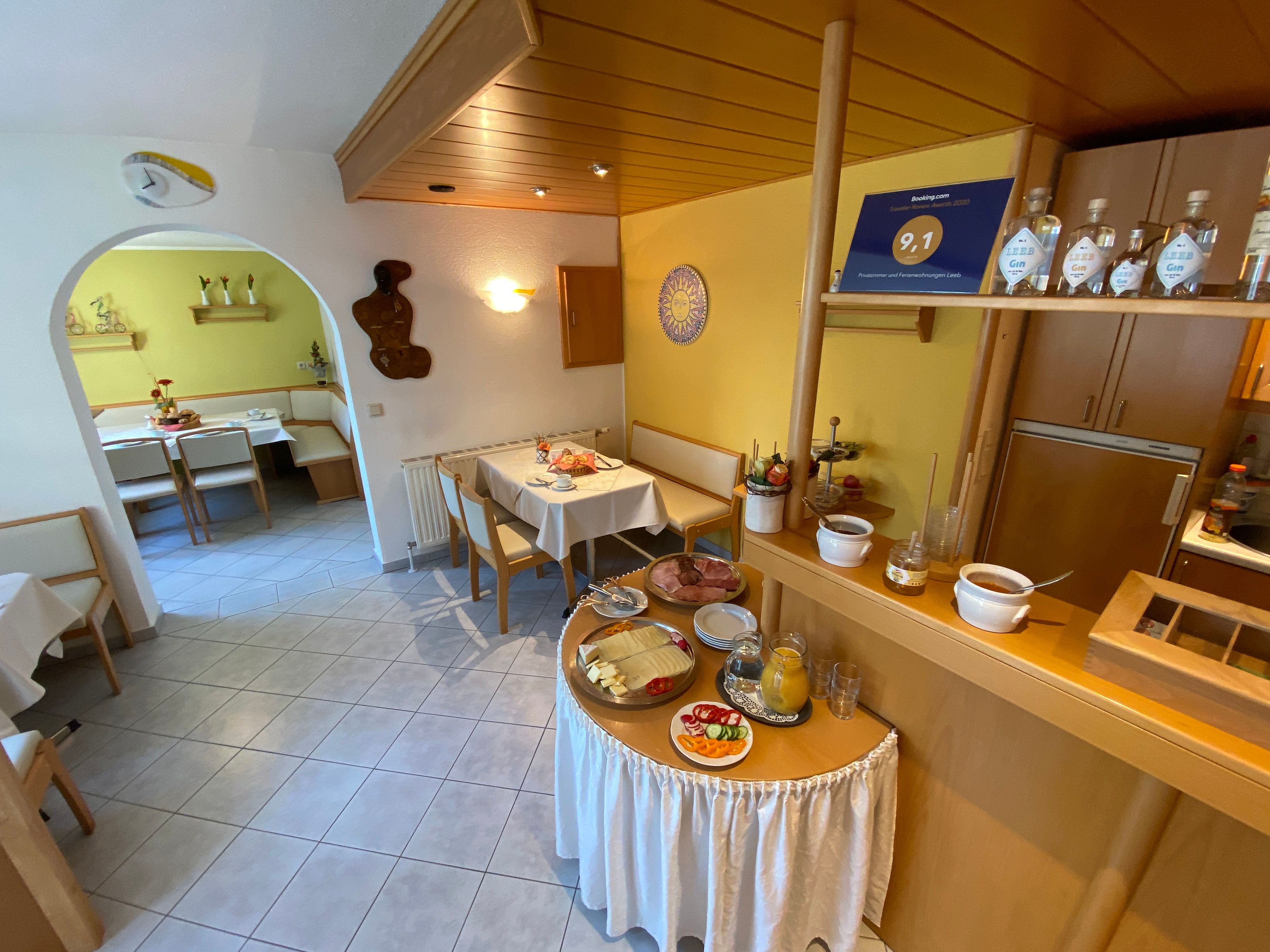 Frühstücksraum mit gedeckten Tischen und Frühstücksbuffet.