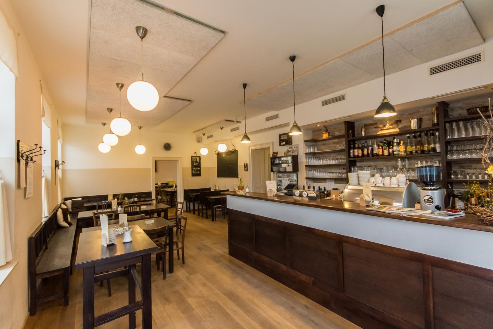 Innenansicht eines gemütlichen Wirtshauses mit Holzmöbeln und Theke.