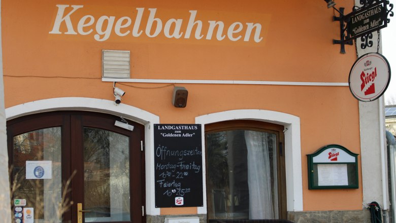 Eingang eines Landgasthauses mit der Aufschrift 'Kegelbahnen' und einem Stiegl-Bierschild.