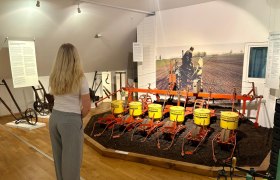 Eine Frau betrachtet eine landwirtschaftliche Ausstellung im Zuckermuseum.