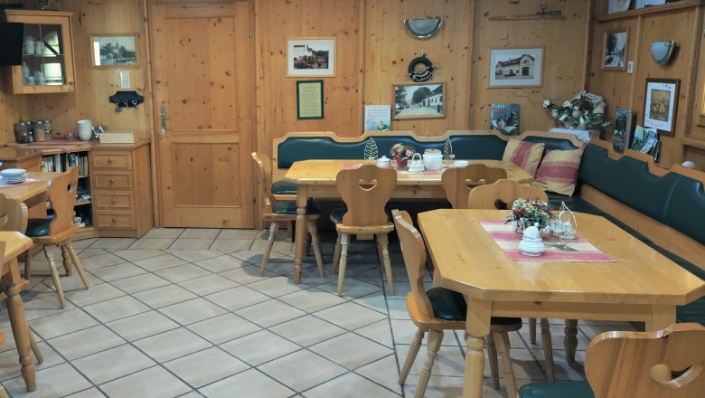 Gem&uuml;tlicher Fr&uuml;hst&uuml;cksraum mit Holzm&ouml;beln und Dekorationen.