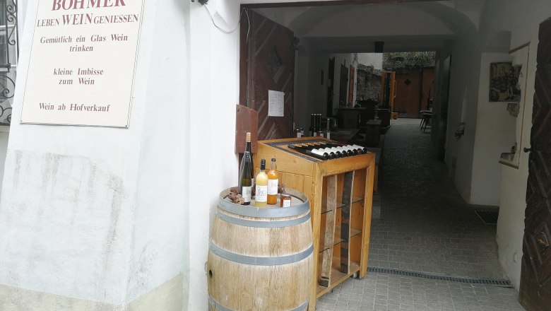Weingut Böhmer Dürnstein, © Roman Zöchlinger Eingang eines Weinguts mit Weinfass und Flaschen.
