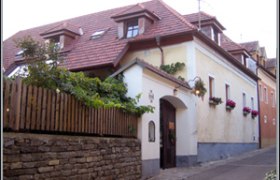 Traditionelles Haus mit rotem Ziegeldach und Blumenkästen an den Fenstern.