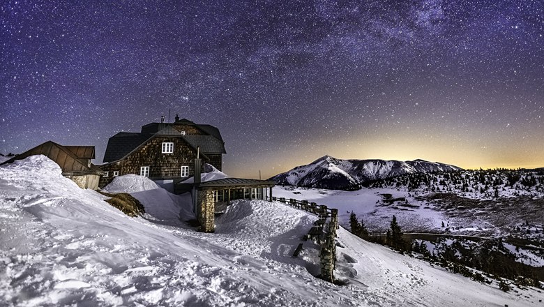 Bergh&uuml;tte im Schnee unter einem klaren Sternenhimmel.