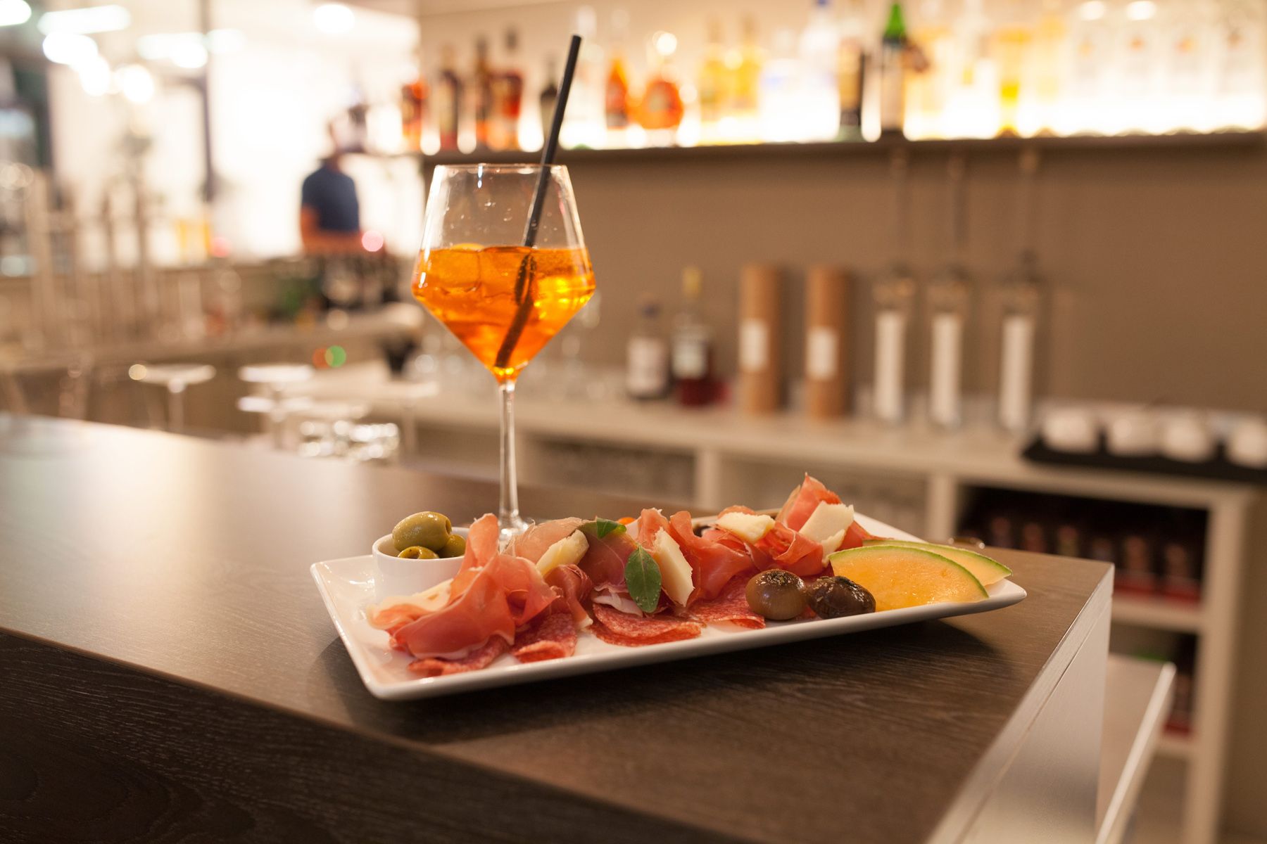 Kleiner Imbis und Getränk im Weinglas stehen an der Hotelbar