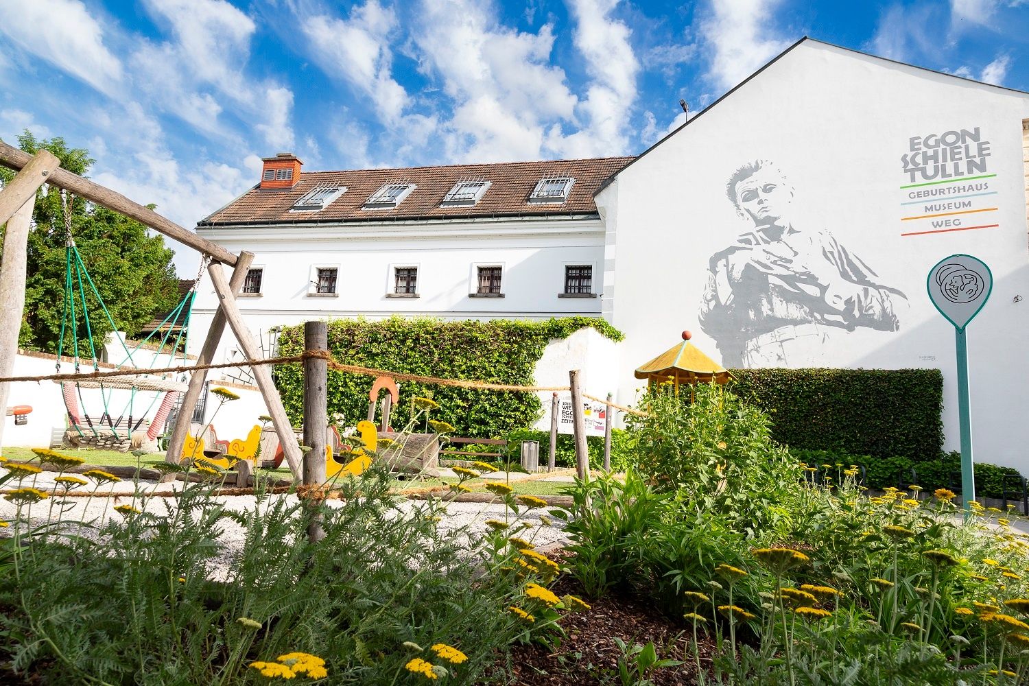 Spielplatz vor dem Egon Schiele Geburtshaus in Tulln mit Wandgemälde.