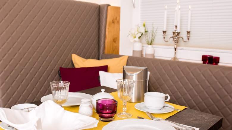 Eleganter Fr&uuml;hst&uuml;ckstisch mit gelbem L&auml;ufer, Geschirr, Gl&auml;sern und Kerzenleuchter.