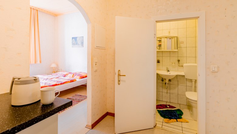 Innenansicht einer Ferienwohnung mit Blick auf Schlafzimmer und Badezimmer.