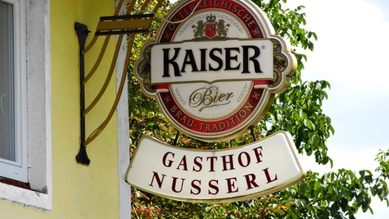 Schild des Gasthofs Nusserl mit Kaiser Bier Logo.