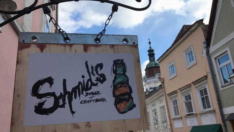 Schild von Schmid's Burger und Craftbeer an einer Hauswand in einer Altstadtstra&szlig;e.