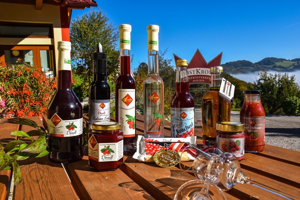 Regionale Dirndl-Spezialitäten von FuXsteiner – von Edelbränden und Likören bis zu Marmeladen und Sirupen – liebevoll präsentiert vor der malerischen Landschaft des Mostviertels.