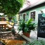 Gemütlicher Gastgarten mit Holzbänken und Tafel im Wirtshaus Bonka, Wienerwald.