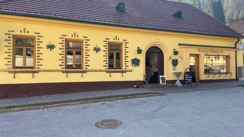 Gelbes Geb&auml;ude mit der Aufschrift 'Fleischhauerei' und einem Eingang.