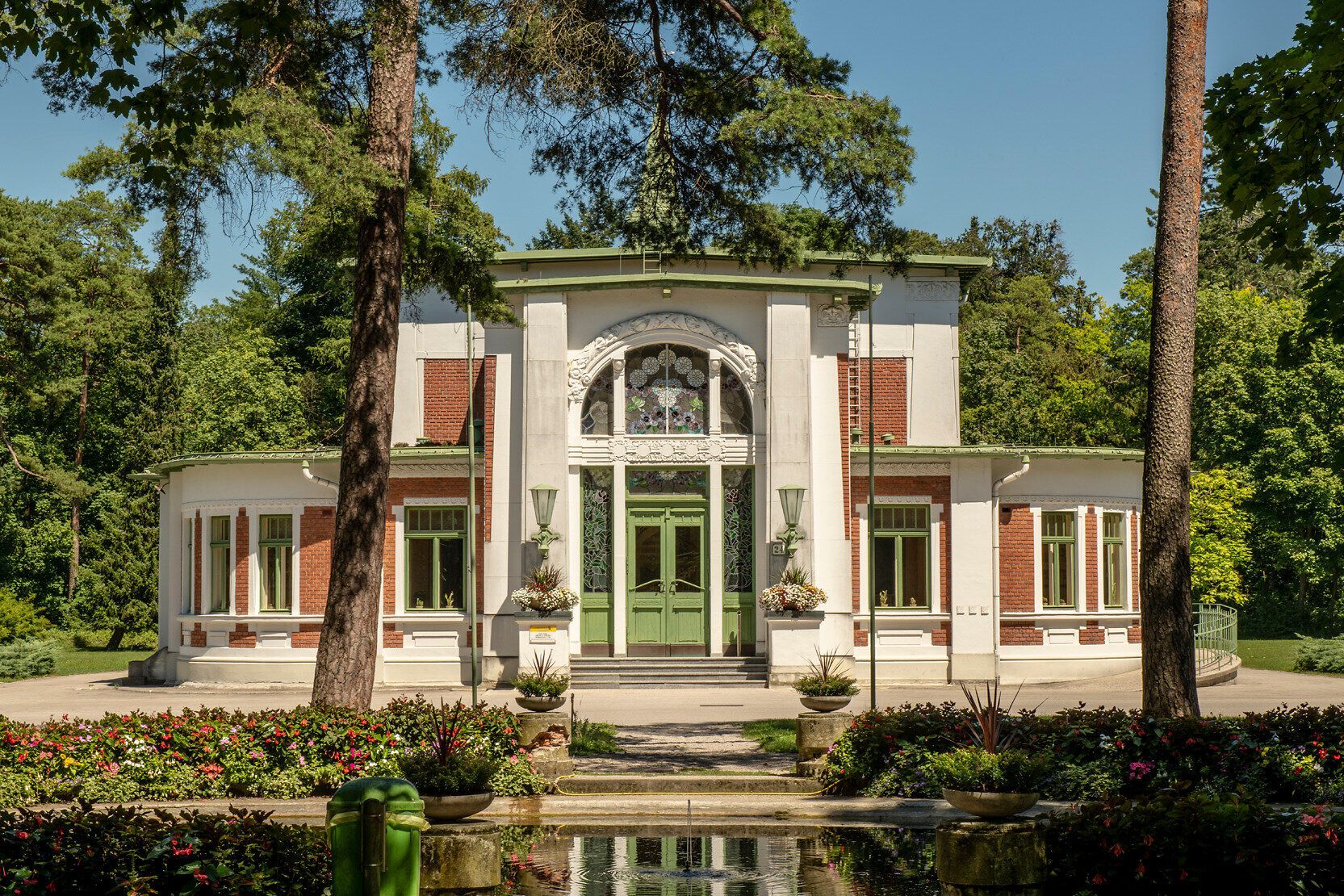 Historischer Pavillon im Park des Landesklinikums Mauer im Mostviertel mit Jugendstil-Elementen, umgeben von altem Baumbestand und gepflegten Gartenanlagen.