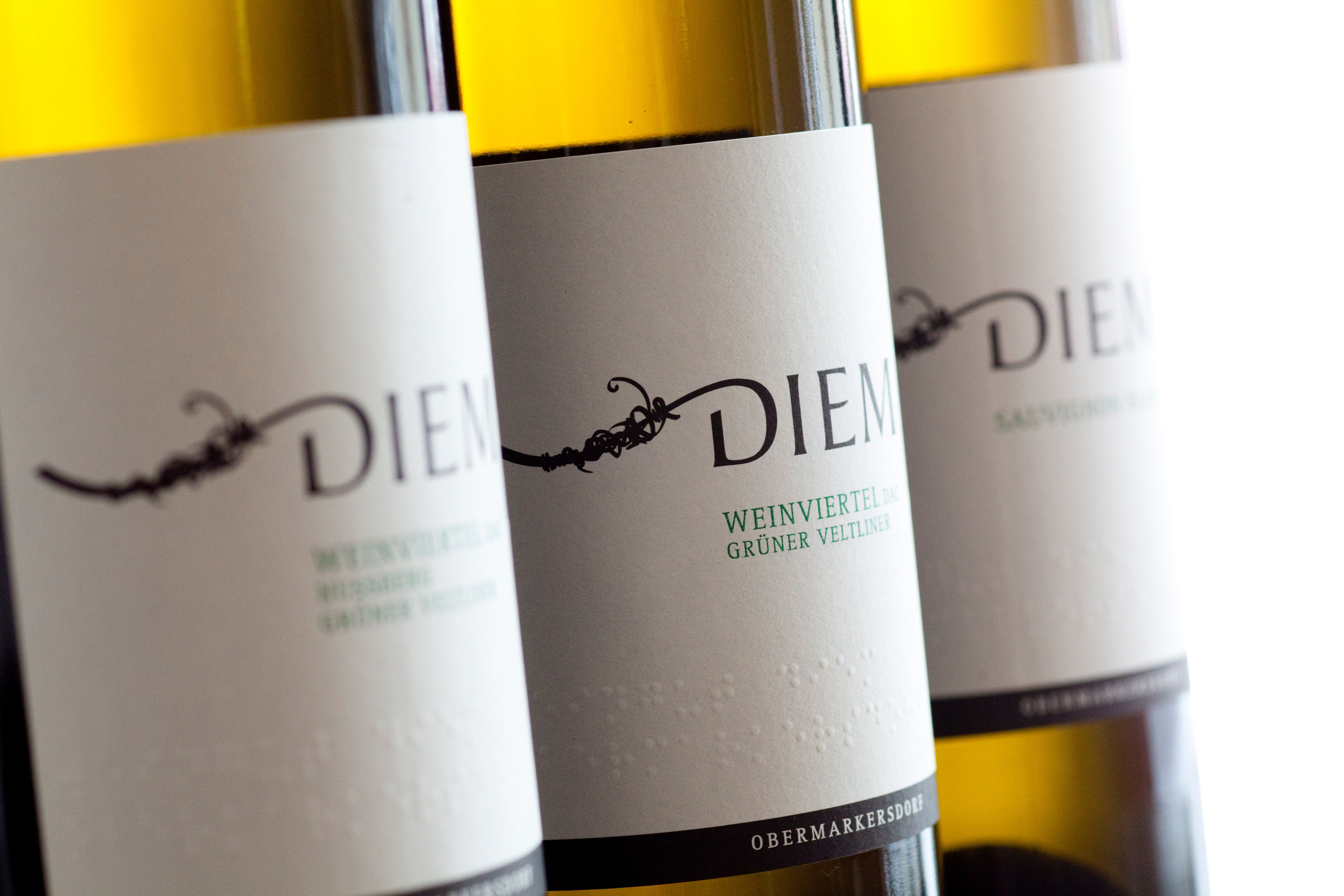 Nahaufnahme von Diem Weinflaschen mit Etiketten für Grüner Veltliner und Sauvignon Blanc.