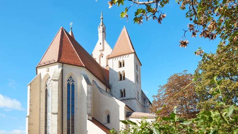 Kirche in Eggenburg mit roten D&auml;chern und blauem Himmel.