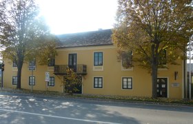 Gelbes Geb&auml;ude mit Balkon und B&auml;umen davor, Erzherzog Carl Haus und Napoleonmuseum in Deutsch-Wagram.