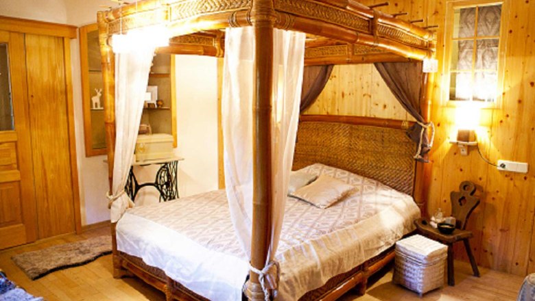 Gemütliches Schlafzimmer mit Himmelbett aus Holz und rustikaler Einrichtung.