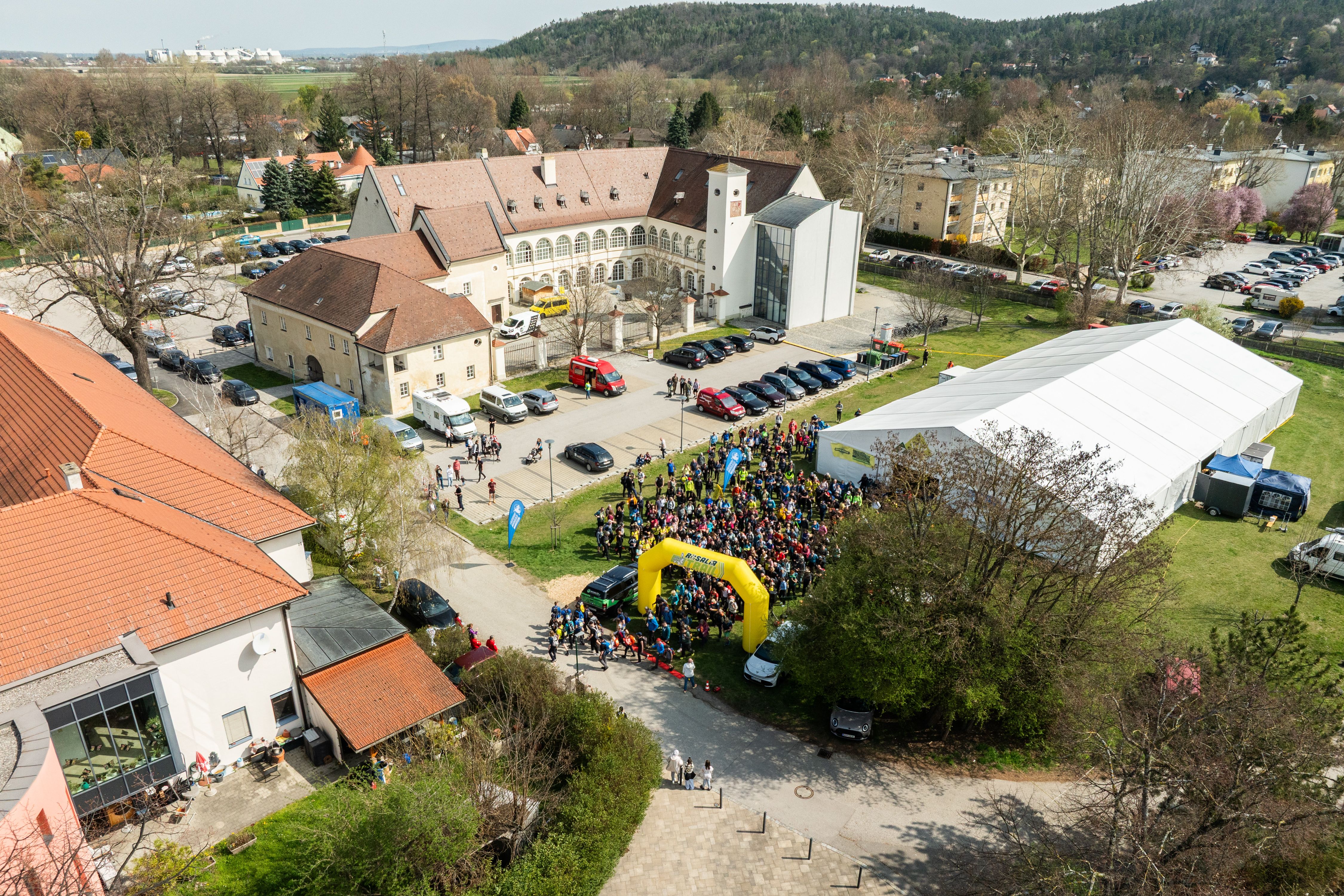 Luftaufnahme eines Schlosses mit Menschenmenge, Zelten und Gebäuden, während der Rosalia Trail Challenge.
