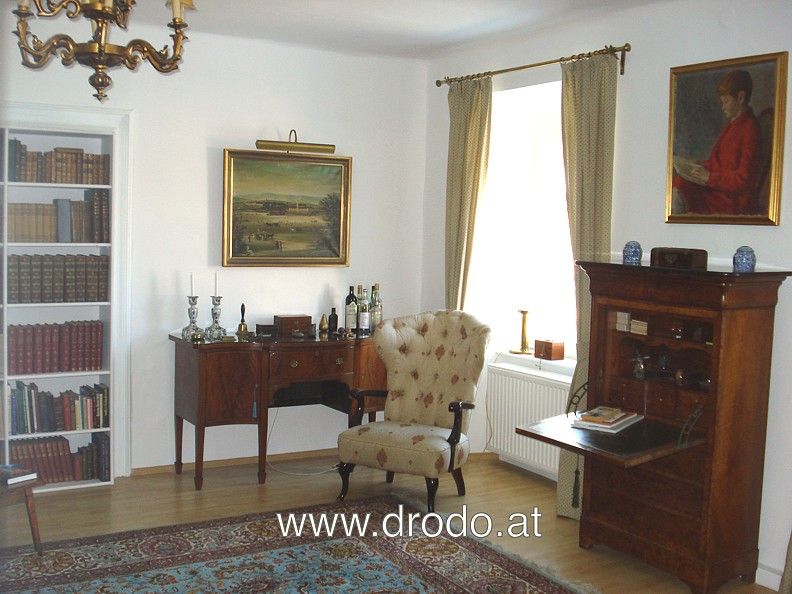 Klassisches Wohnzimmer mit antiken Möbeln, Gemälden und Bücherregal.