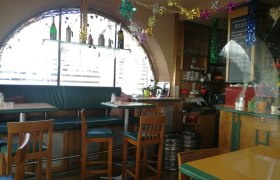 Innenansicht eines gemütlichen Cafés mit Dekorationen und Sitzgelegenheiten.