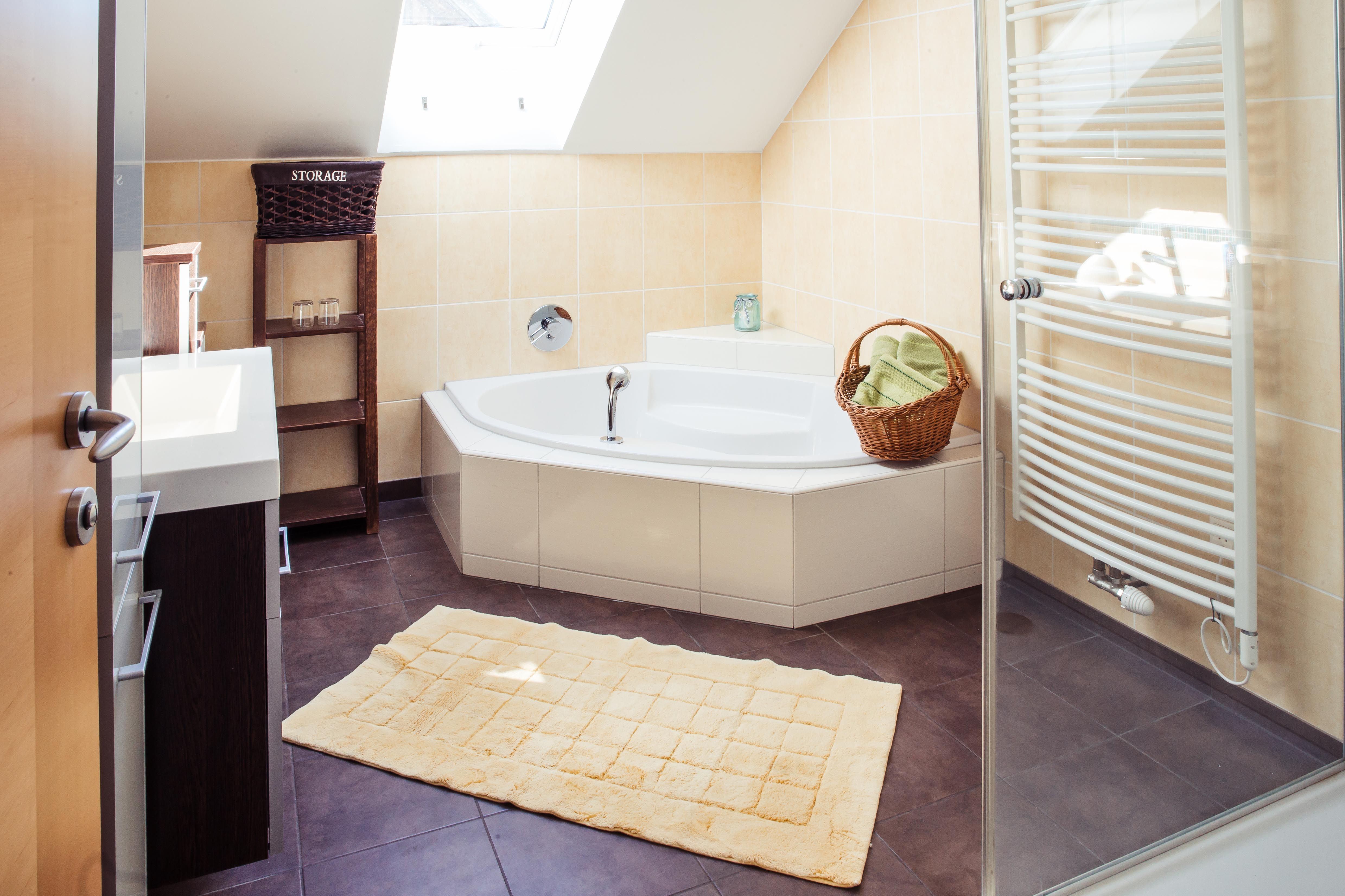 Modernes Badezimmer mit Badewanne, Handtuchhalter und Dachfenster.
