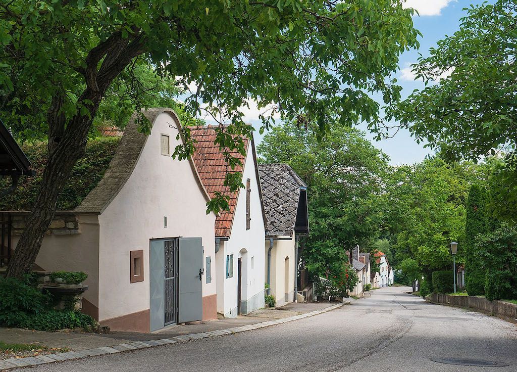 Eine malerische Kellergasse mit traditionellen Häusern und Bäumen in Stixneusiedl, Niederösterreich