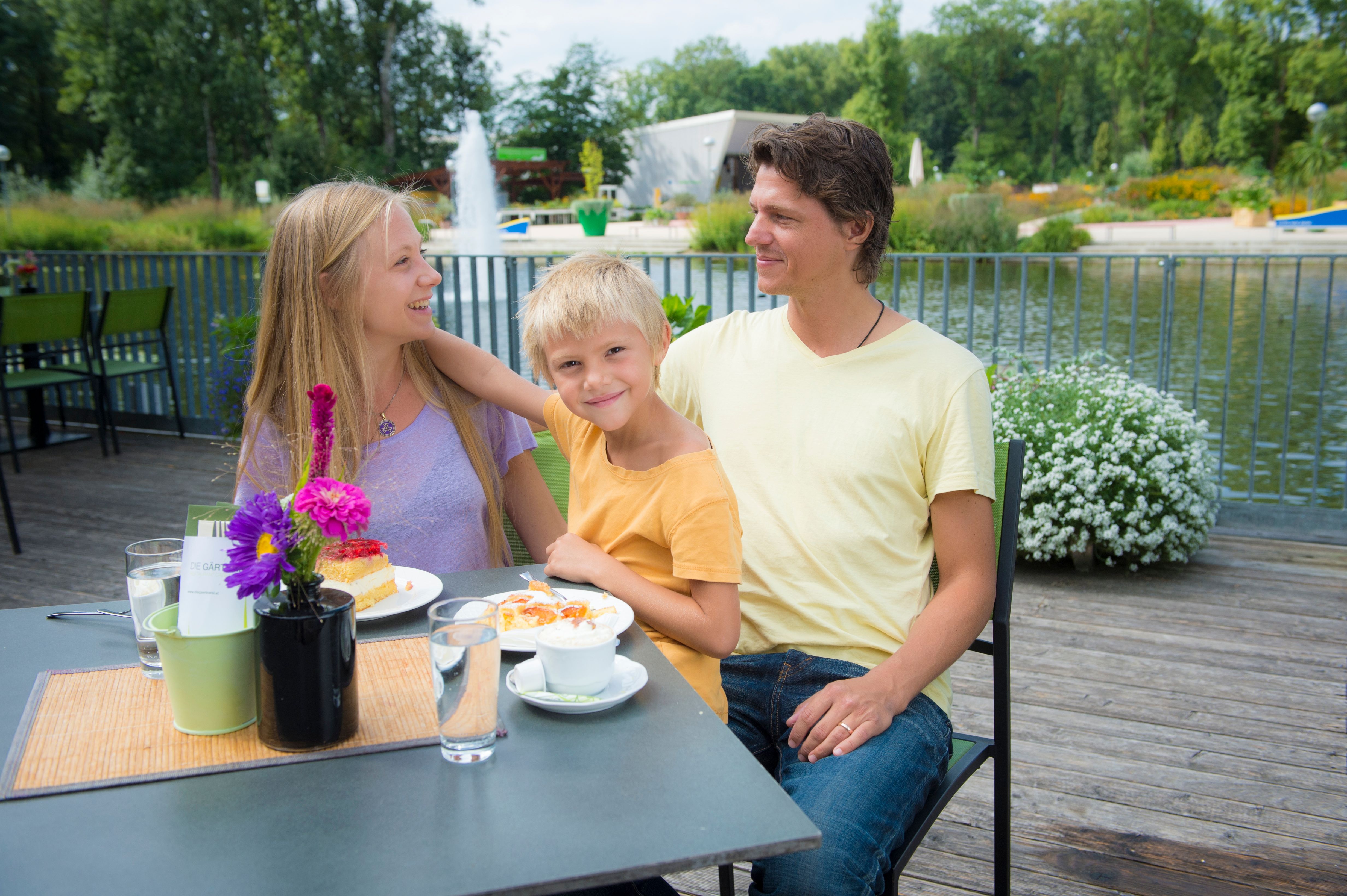 Familie sitzt auf der Terrasse des Restaurants 