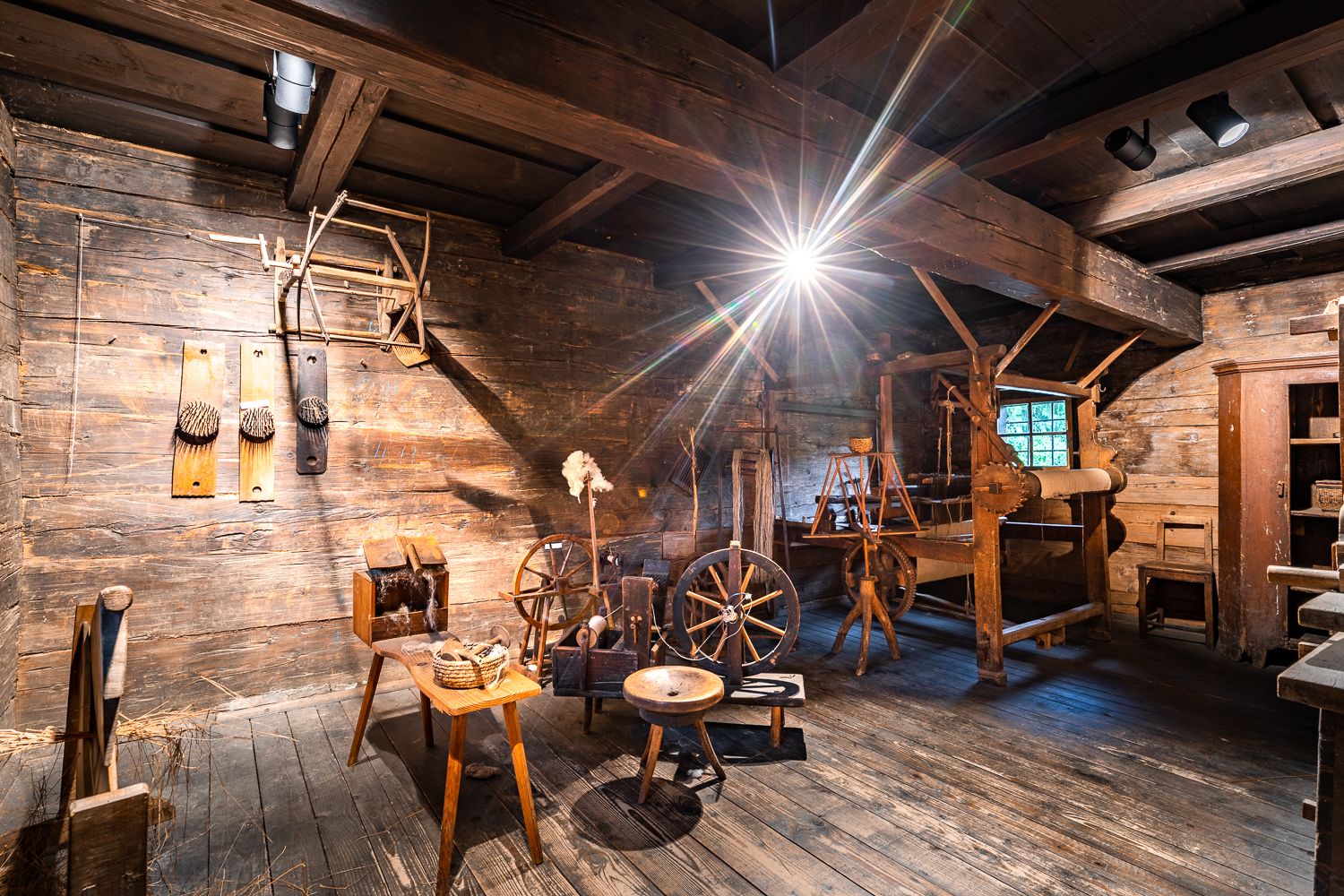 Innenansicht einer alten Werkstatt mit Holzgeräten und Spinnrädern im Museumsdorf Krumbach.