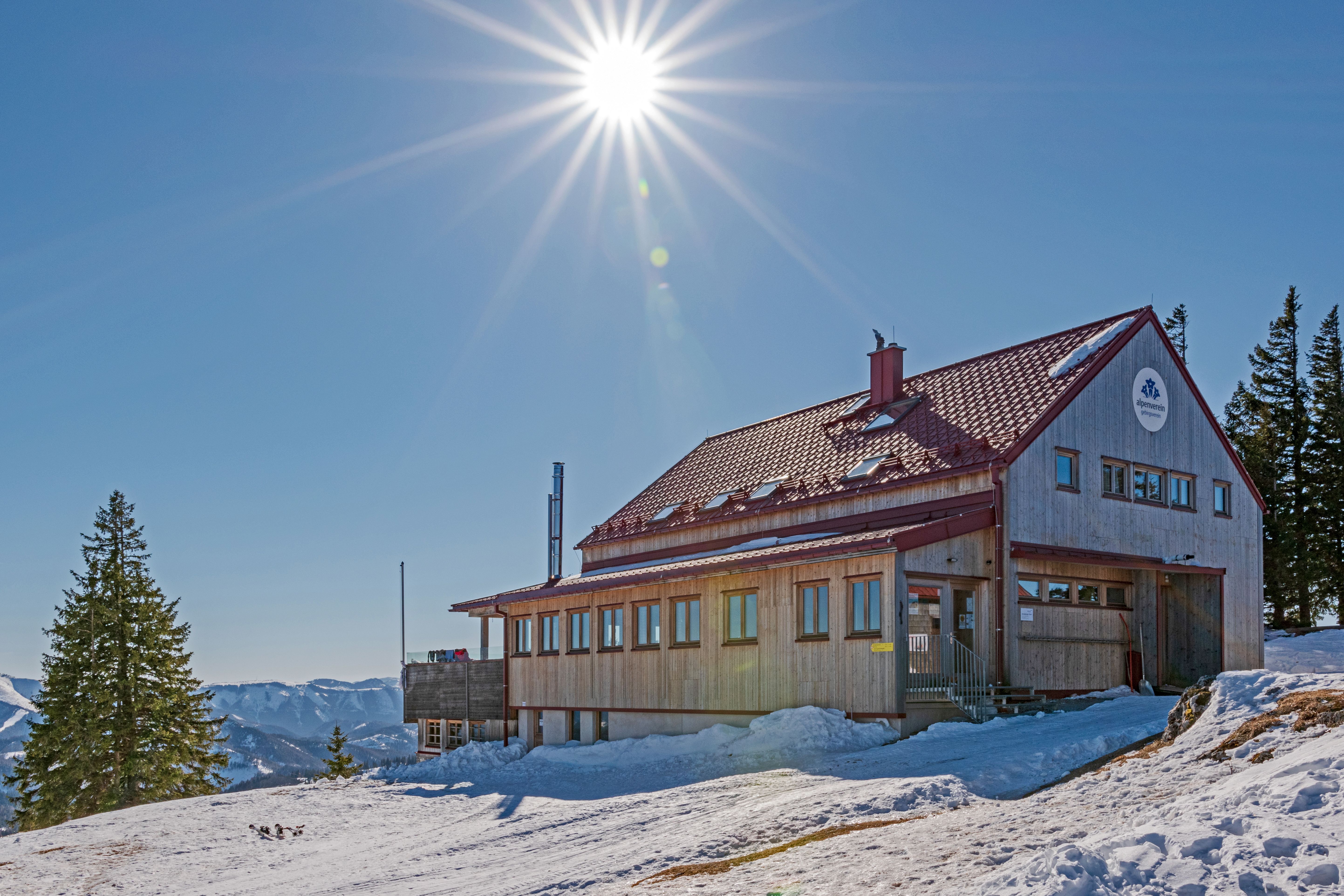Umgeben von schneebedeckten Bergen strahlt das Annaberger Haus eine einladende Wärme aus. Die klare Winterluft und die strahlende Sonne schaffen eine perfekte Kulisse für Skitouren und entspannte Momente in der Natur.