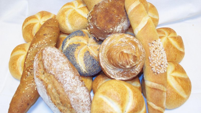 Verschiedene Br&ouml;tchen und Brote auf einem wei&szlig;en Tuch arrangiert.
