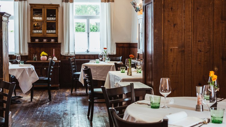 Gem&uuml;tliches Wirtshaus mit Holzm&ouml;beln und gedeckten Tischen.
