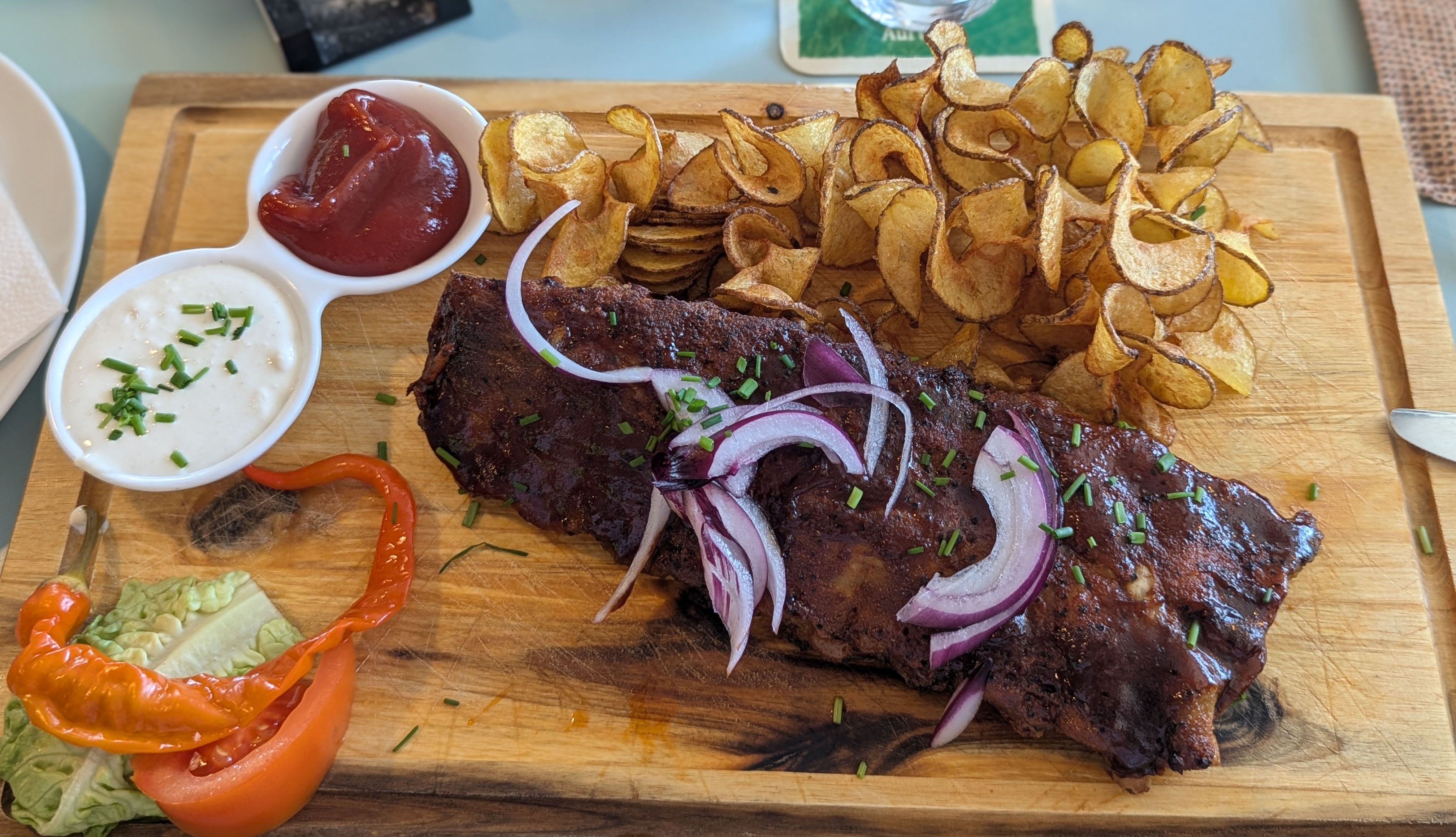 Spareribs und Spiralkartoffeln auf einem Holzbrett.