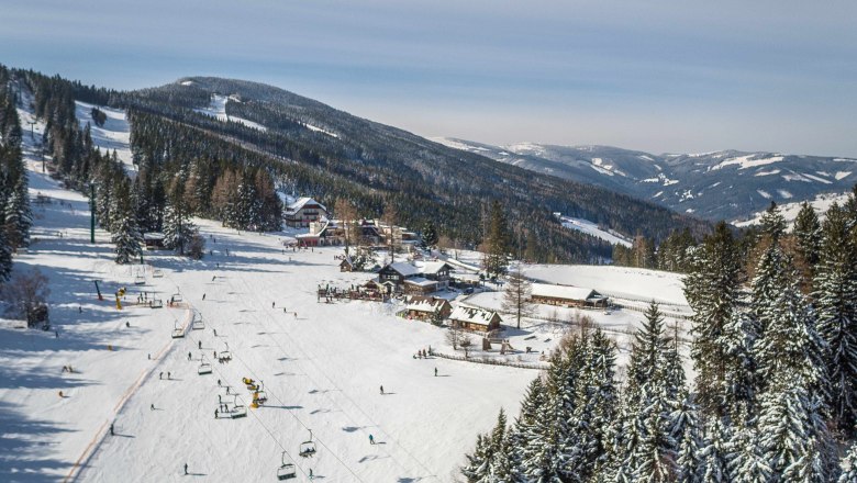Winterlandschaft mit Skilift und verschneiten Bergen in Mönichkirchen.