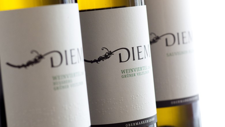 Nahaufnahme von Diem Weinflaschen mit Etiketten f&uuml;r Gr&uuml;ner Veltliner und Sauvignon Blanc.