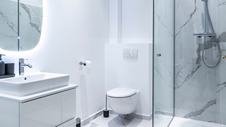 Modernes Badezimmer mit Dusche, Toilette und Waschbecken.