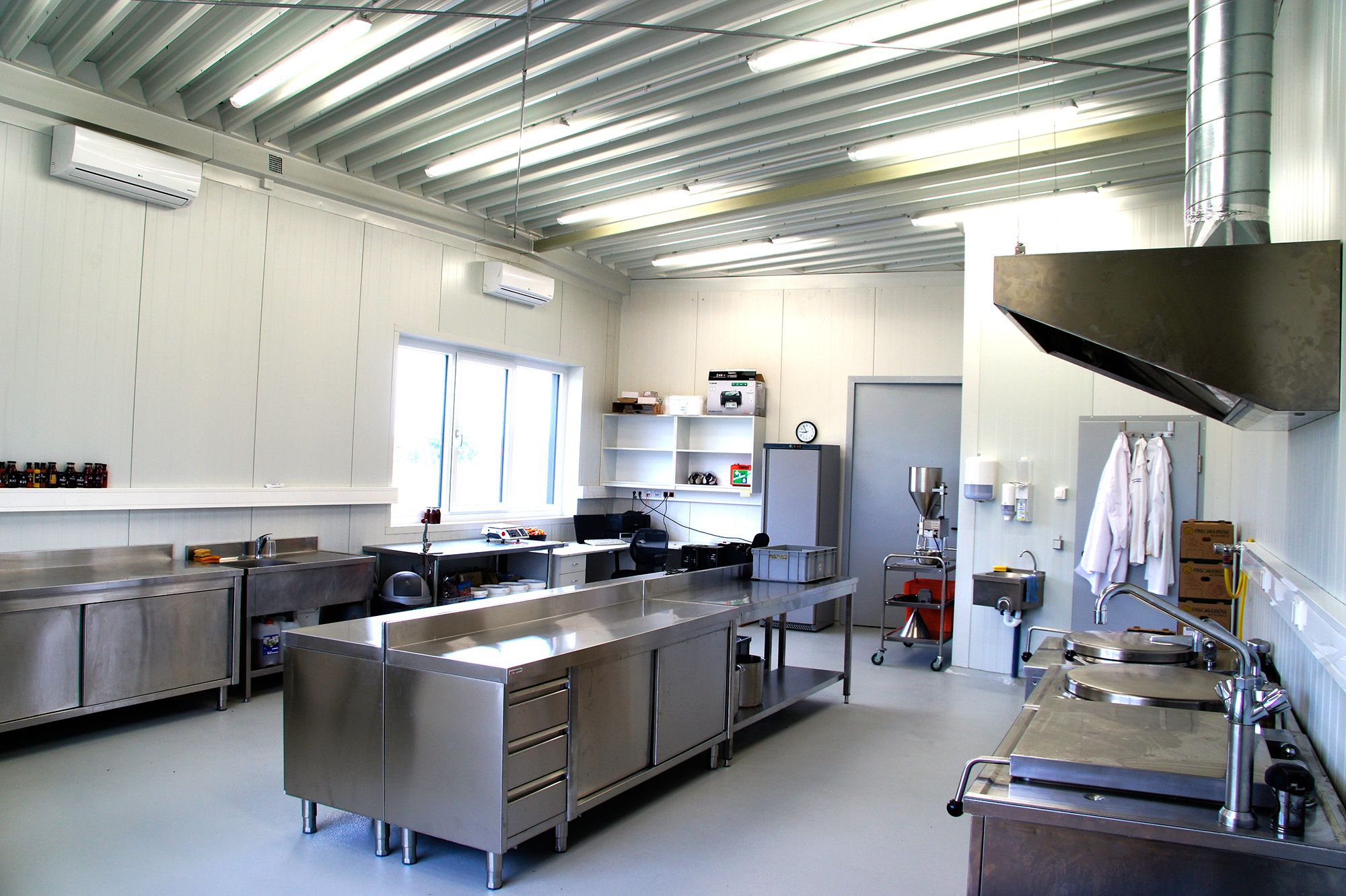 Moderne Industrieküche mit Edelstahlmöbeln und Geräten.