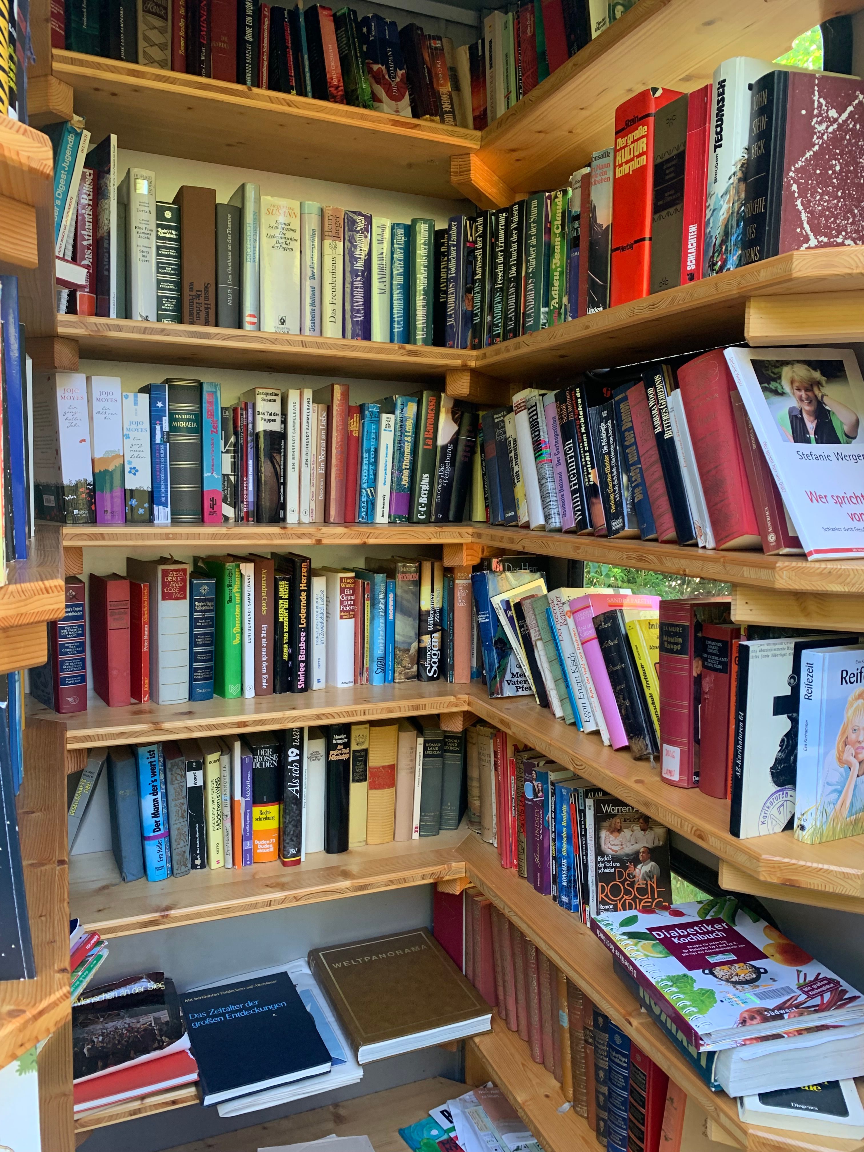 Ein Bücherregal mit verschiedenen Büchern in einem öffentlichen Bücherschrank.