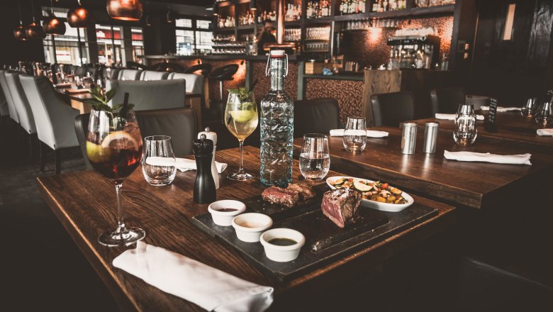 Elegantes Restaurant mit gedecktem Tisch, Getr&auml;nken und Speisen.