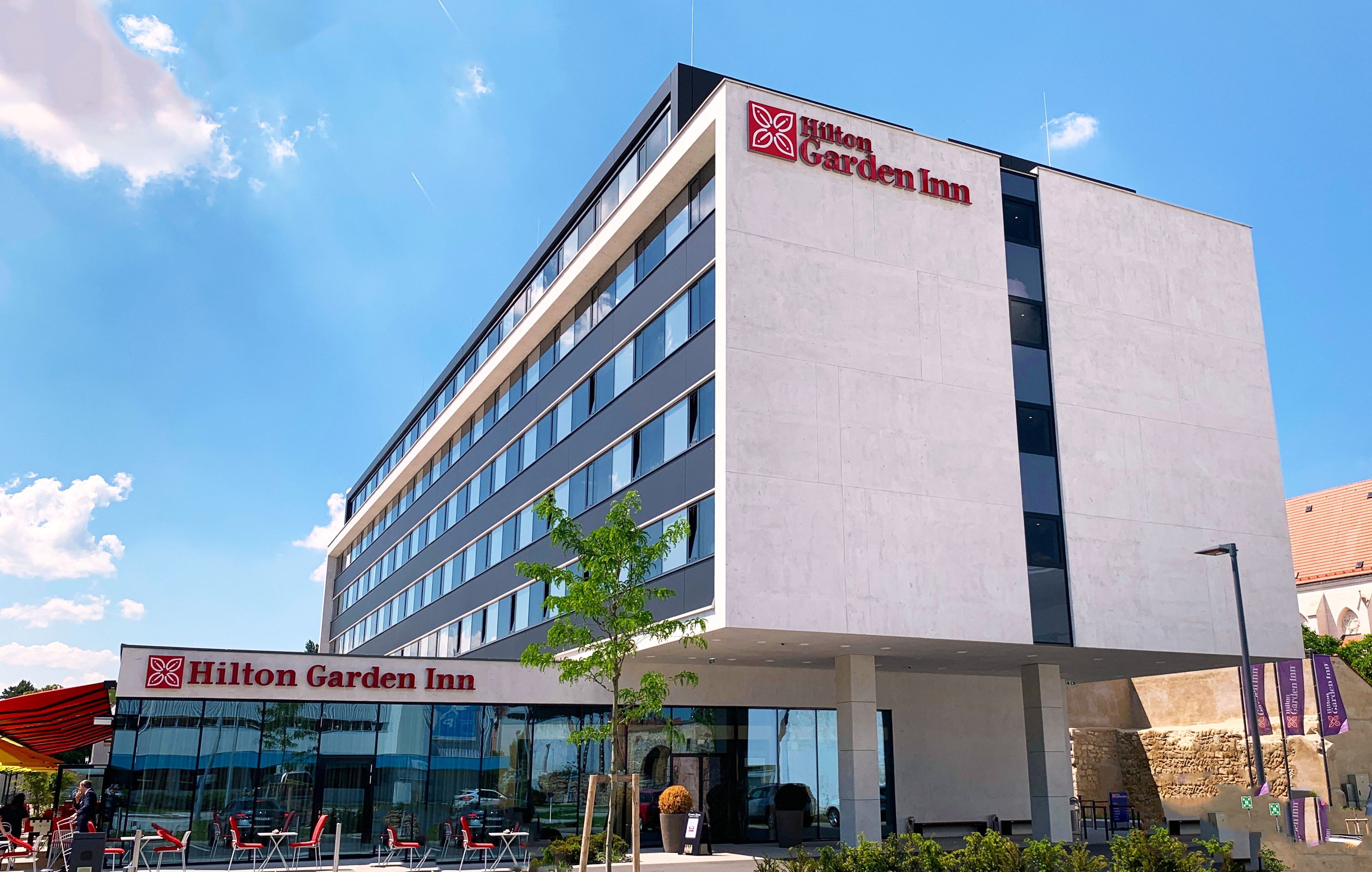 Außenansicht des Hilton Garden Inn in Wiener Neustadt bei sonnigem Wetter.