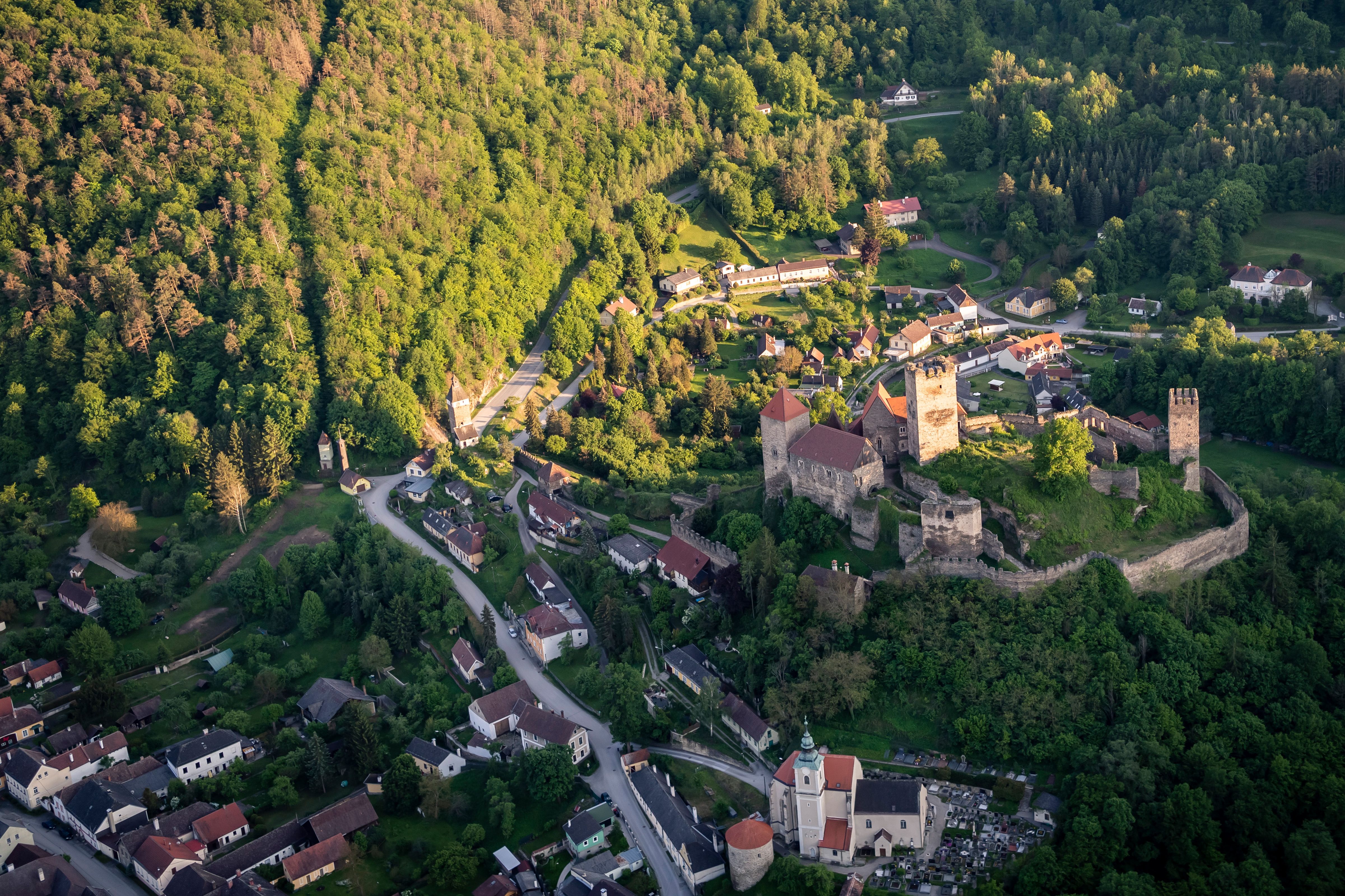 Luftaufnahme der Burg Hardegg inmitten einer grünen Landschaft.