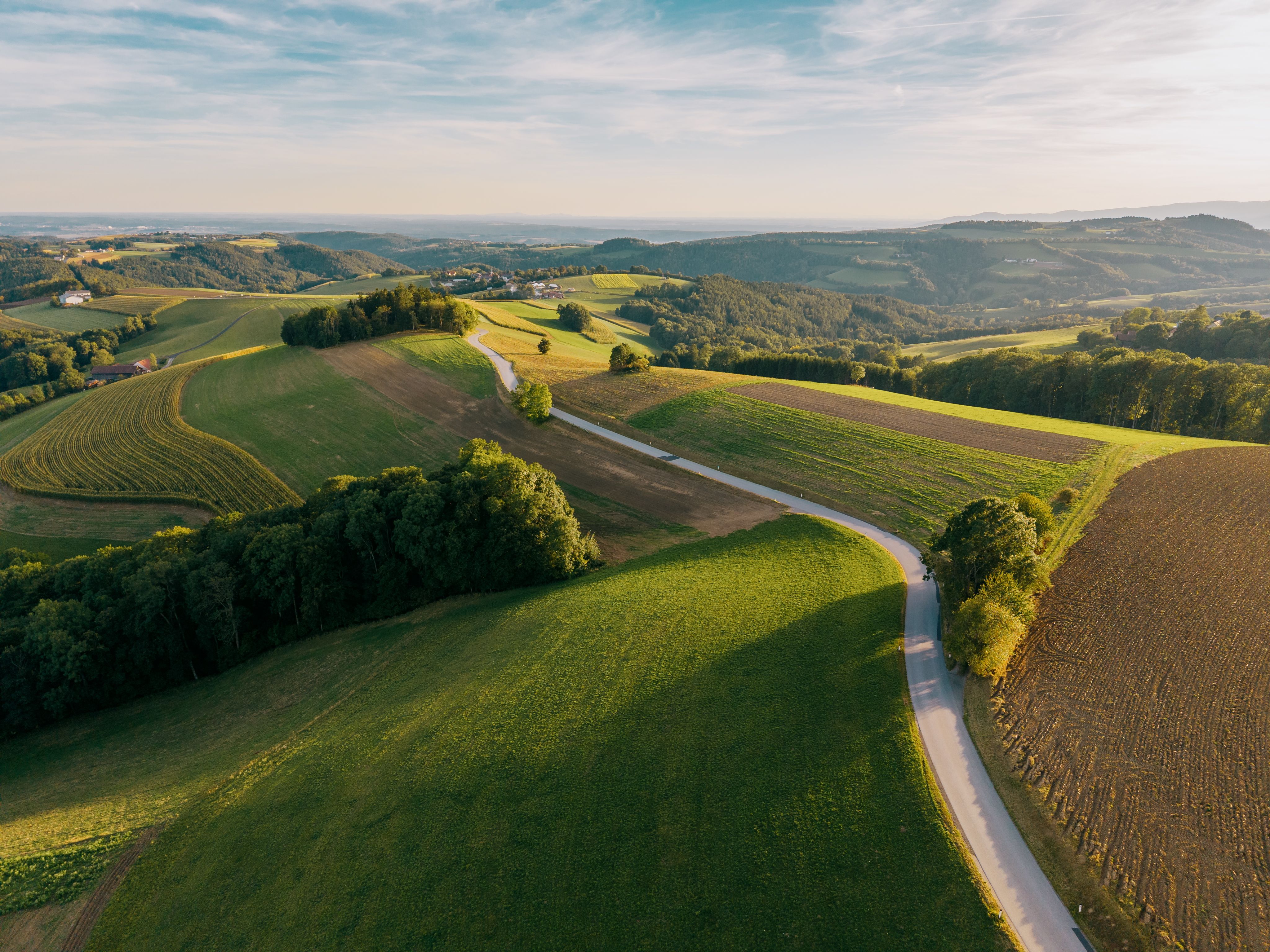 Luftaufnahme einer hügeligen Landschaft mit Feldern und Wäldern in Hattmannsdorf, Hochneukirchen.